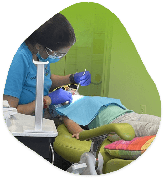 Agent T examining a child's smile in dental chair