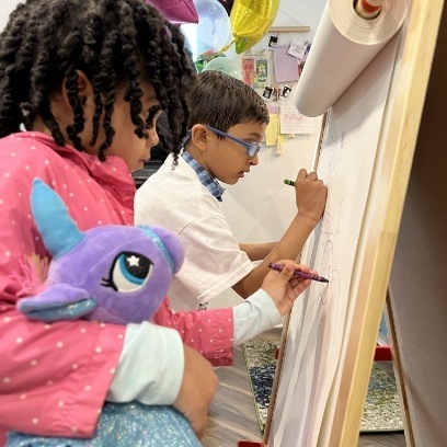 Two children coloring with crayons during first visit to Leesburg pediatric dental office