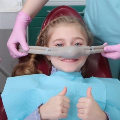 Young girl giving thumbs up while visiting sedation dentist for kids in Leesburg