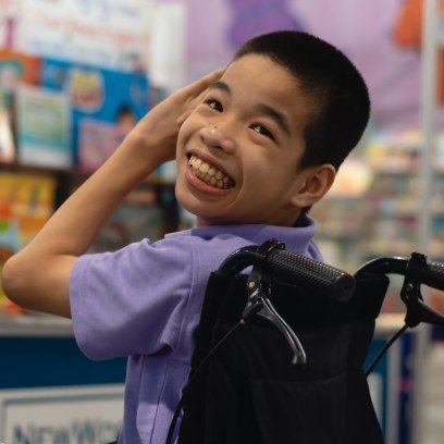 Young boy in wheelchair turning to smile at the camera