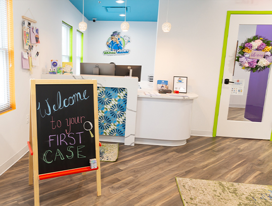 Pediatric dental office waiting room with standing chalkboard saying welcome to your first case
