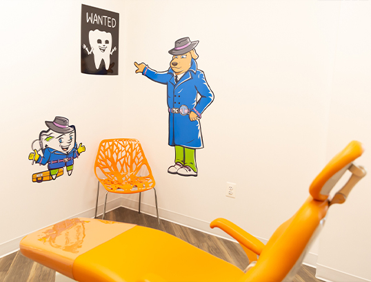 Cartoon tooth and dog detective characters on wall of pediatric dental treatment room