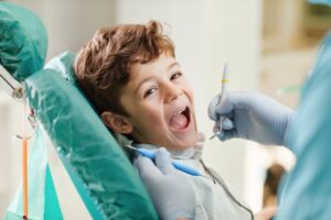 a child sitting in a dental chair having their teeth examined