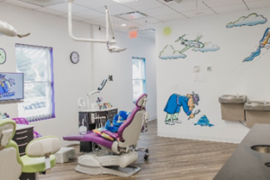a purple dental chair with a blue stuffed dinosaur in it
