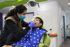 Dr. Vani Takiar taking a child&rsquo;s X-rays at a dental office